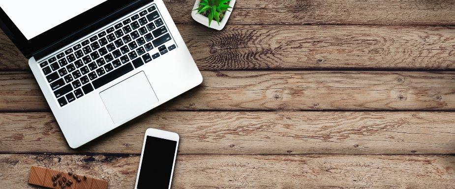 Computer and phone on wooden table