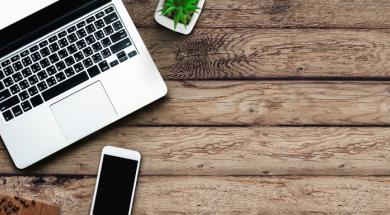 Computer and phone on wooden table